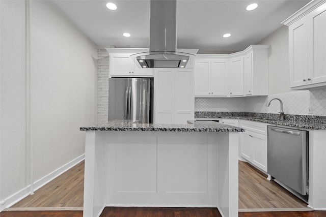 1608 N 17th St, Waco, TX 76707 - kitchen with stainless steel appliances, a sink, island range hood, dark stone countertops, and white cabinetry