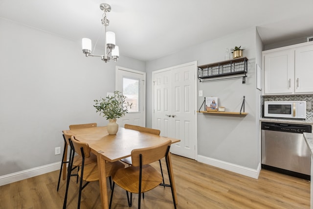 559 Bell Dr, Allen, TX 75002 - dining area with baseboards, light wood-style floors, and a chandelier