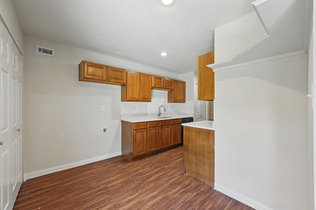 1908 Rutherford Ln, Arlington, TX 76014 - kitchen with a sink, brown cabinetry, dark wood-type flooring, light countertops, and baseboards