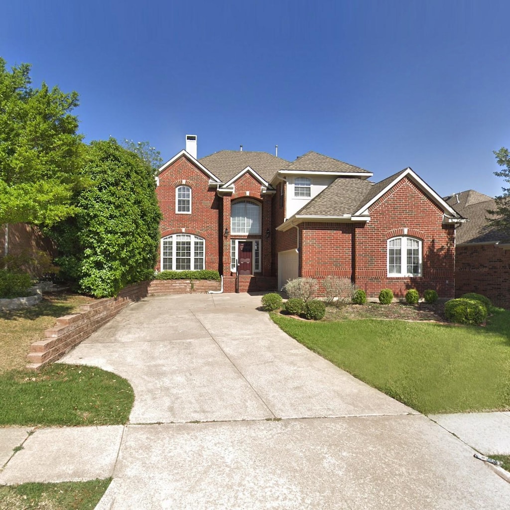 2505 Links Dr, Plano, TX 75093 - traditional-style home with brick siding, driveway, a chimney, and a front yard