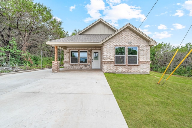 915 Comanche Cove Dr, Granbury, TX 76048 - view of front of home featuring board and batten siding, brick siding, a front yard, driveway, and a shingled roof