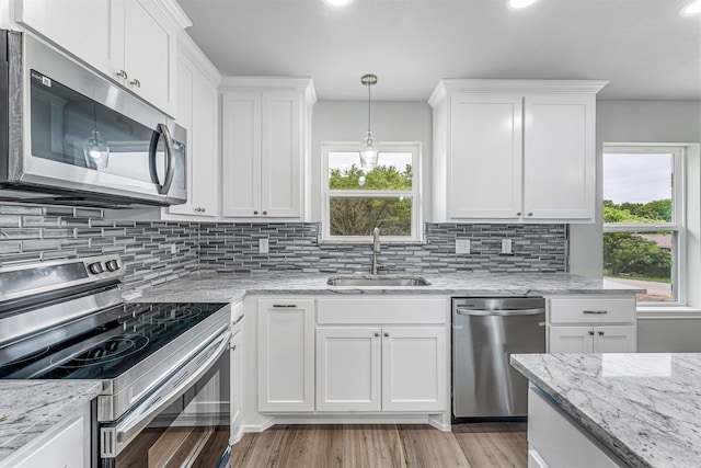 915 Comanche Cove Dr, Granbury, TX 76048 - kitchen with stainless steel appliances, a sink, plenty of natural light, light wood-type flooring, and recessed lighting
