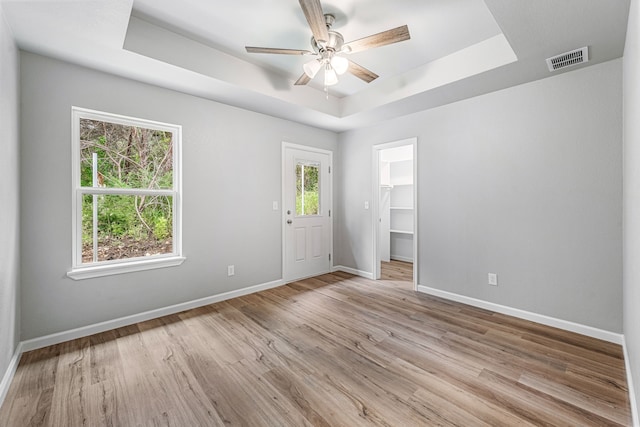 915 Comanche Cove Dr, Granbury, TX 76048 - empty room with a tray ceiling, baseboards, a ceiling fan, and light wood finished floors