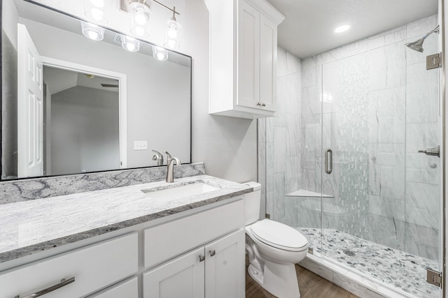 915 Comanche Cove Dr, Granbury, TX 76048 - full bathroom featuring a shower stall, vanity, wood finished floors, and toilet