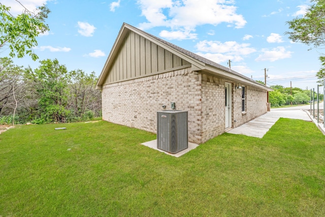 915 Comanche Cove Dr, Granbury, TX 76048 - view of side of property with board and batten siding, cooling unit, a yard, and brick siding