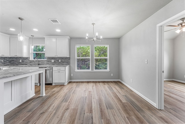 915 Comanche Cove Dr, Granbury, TX 76048 - kitchen with stainless steel dishwasher, a chandelier, white cabinetry, decorative backsplash, and light wood-style floors