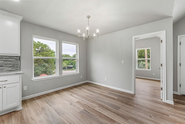 915 Comanche Cove Dr, Granbury, TX 76048 - unfurnished dining area featuring a chandelier, light wood-style floors, and baseboards