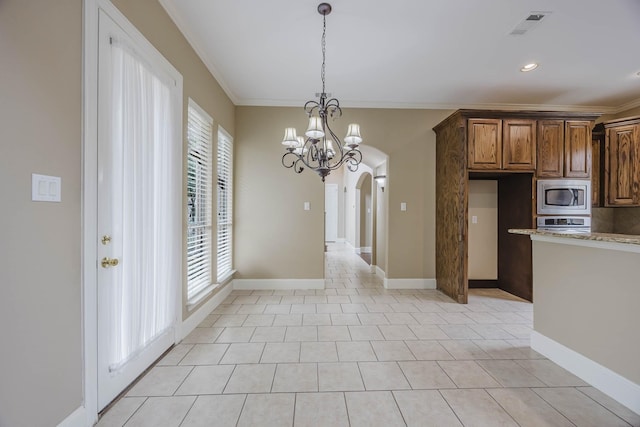 7605 Chief Spotted Tail Dr, Mckinney, TX 75070 - kitchen featuring stainless steel microwave, ornamental molding, a chandelier, arched walkways, and hanging light fixtures