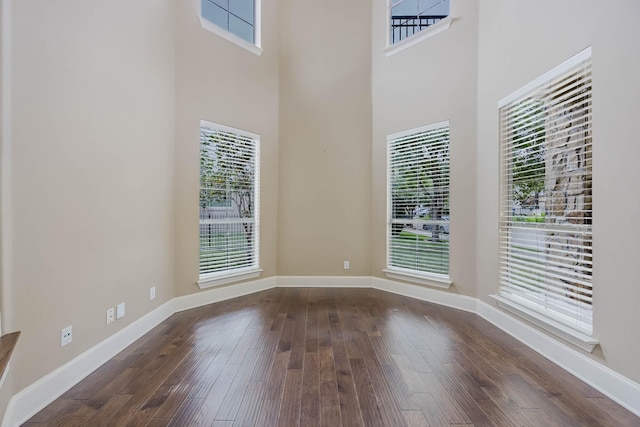 7605 Chief Spotted Tail Dr, Mckinney, TX 75070 - empty room with dark wood finished floors, healthy amount of natural light, and a towering ceiling