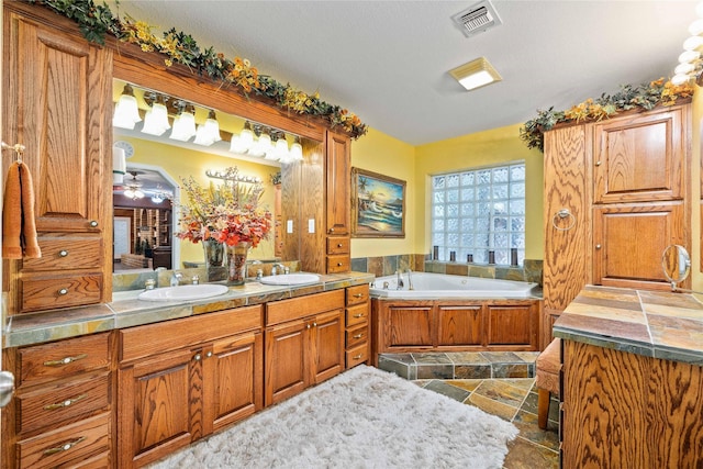 2514 Good Shepherd Dr, Brownwood, TX 76801 - bathroom featuring stone tile floors, a garden tub, double vanity, and a ceiling fan