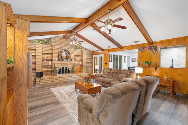 2514 Good Shepherd Dr, Brownwood, TX 76801 - living room with ceiling fan, wood walls, light wood-style flooring, and a fireplace