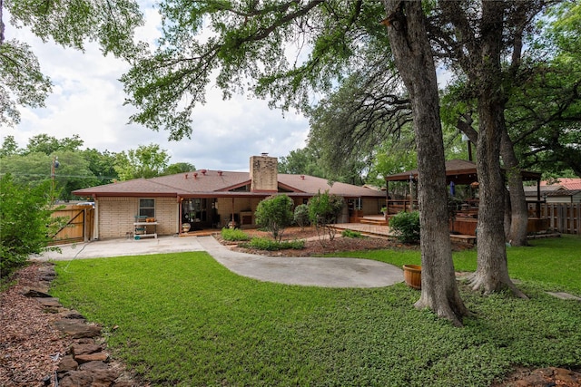 2514 Good Shepherd Dr, Brownwood, TX 76801 - back of property with a gazebo, a patio, a chimney, brick siding, and a gate