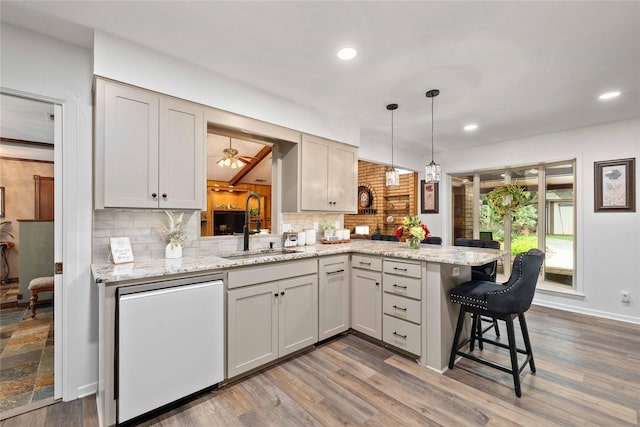 2514 Good Shepherd Dr, Brownwood, TX 76801 - kitchen featuring a sink, decorative backsplash, a peninsula, a breakfast bar, and recessed lighting