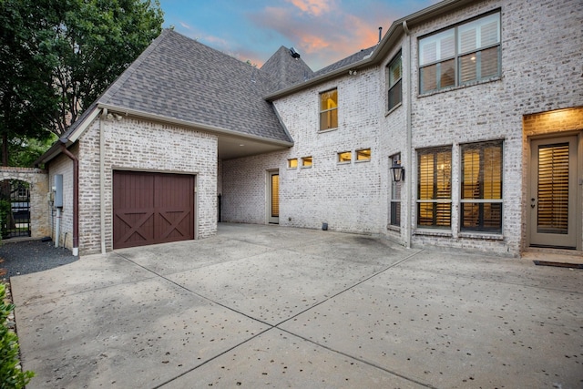 6131 Arboretum Dr, Frisco, TX 75034 - view of front of house featuring driveway, roof with shingles, brick siding, and a garage