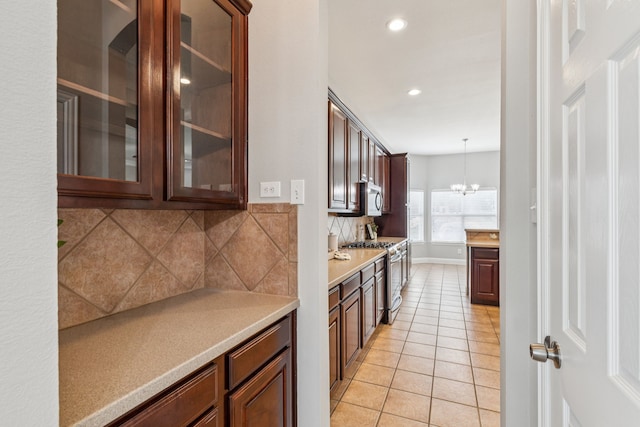1422 Sunscape Way, Garland, TX 75043 - kitchen with stainless steel appliances, backsplash, light countertops, light tile patterned flooring, and a chandelier