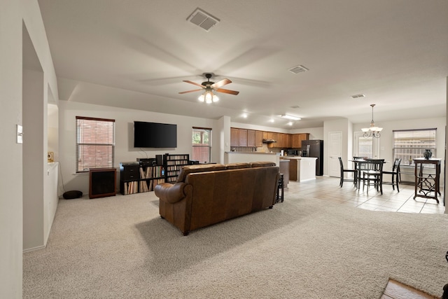 515 Angela Ln, Euless, TX 76039 - living room featuring ceiling fan, light carpet, a chandelier, light tile patterned floors, and baseboards