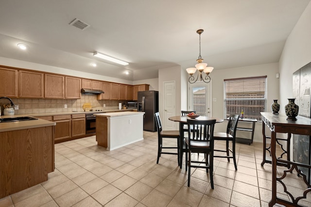 515 Angela Ln, Euless, TX 76039 - kitchen featuring stainless steel appliances, under cabinet range hood, a chandelier, a sink, and tasteful backsplash