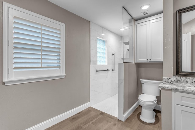 1904 Alston St, Arlington, TX 76013 - bathroom featuring wood finished floors, baseboards, vanity, toilet, and walk in shower