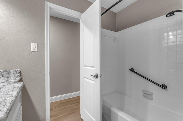 1904 Alston St, Arlington, TX 76013 - bathroom featuring vanity, shower / bathtub combination, wood finished floors, and baseboards