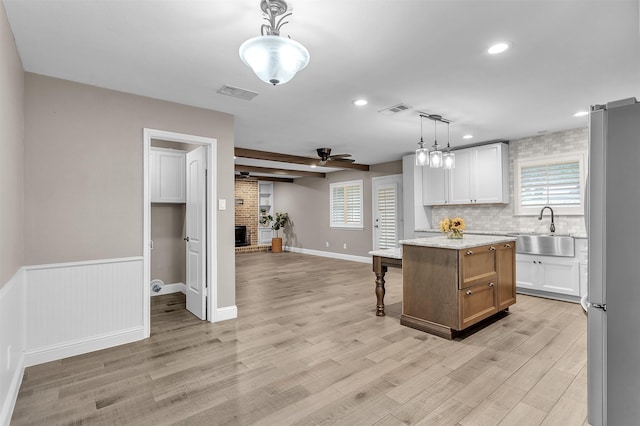 1904 Alston St, Arlington, TX 76013 - kitchen with a sink, freestanding refrigerator, light wood-style floors, a fireplace, and tasteful backsplash