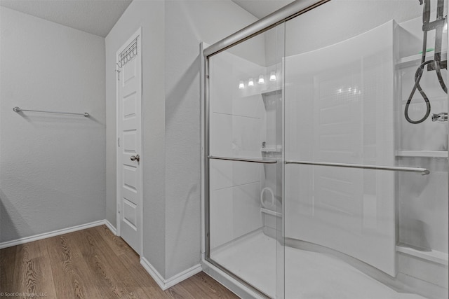 129 Clear Creek Ln, Terrell, TX 75160 - bathroom featuring wood finished floors, a shower stall, and baseboards
