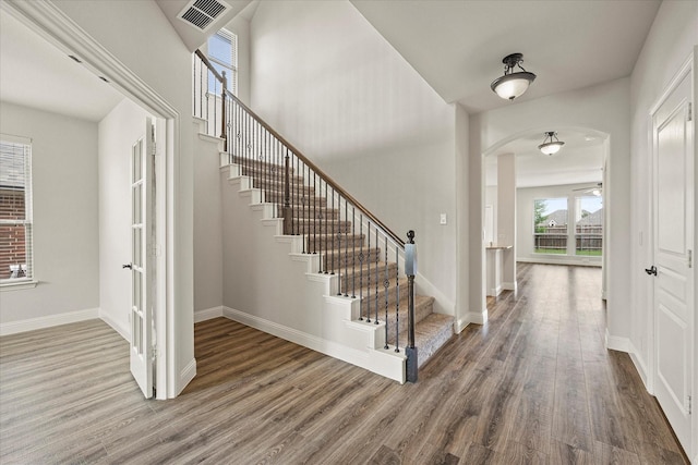 946 Mangrove Dr, Fate, TX 75087 - foyer featuring wood finished floors, arched walkways, stairs, and baseboards