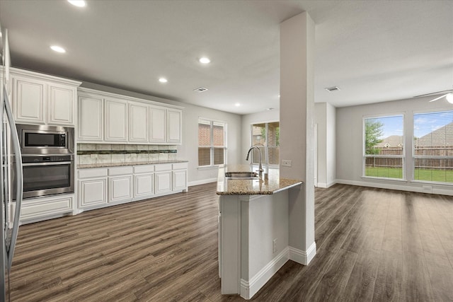 946 Mangrove Dr, Fate, TX 75087 - kitchen with appliances with stainless steel finishes, a sink, dark wood-style floors, healthy amount of natural light, and recessed lighting