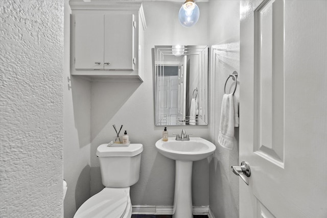 5556 Canada Ct, Rockwall, TX 75032 - half bathroom with toilet, a textured wall, and a sink