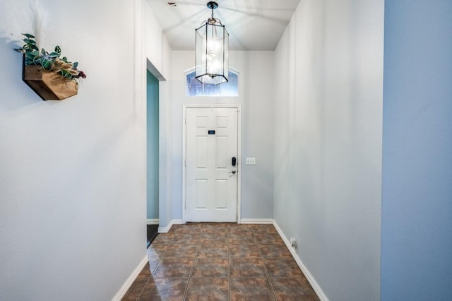 1004 Broken Spoke Dr, Little Elm, TX 75068 - doorway with baseboards, a chandelier, and stone finish flooring
