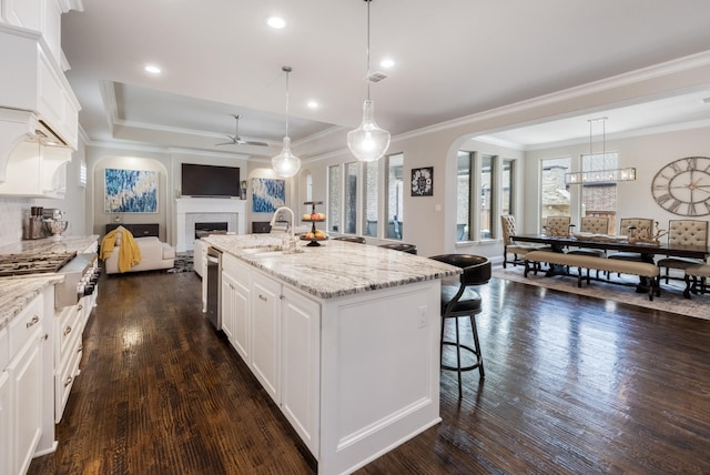 1201 White Squall Trl, Arlington, TX 76005 - kitchen featuring a sink, ceiling fan, a fireplace, open floor plan, and arched walkways