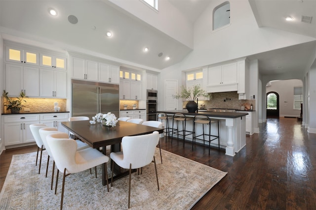 3690 Guinn Gate Dr, Frisco, TX 75034 - dining area with arched walkways, dark wood-type flooring, high vaulted ceiling, and recessed lighting