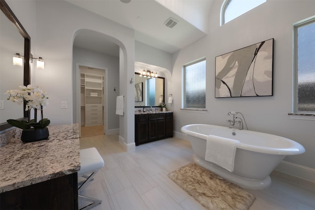 3690 Guinn Gate Dr, Frisco, TX 75034 - bathroom with a soaking tub, vanity, a walk in closet, and baseboards