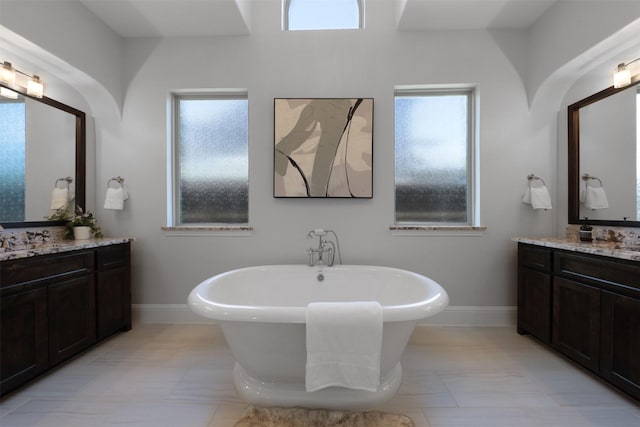 3690 Guinn Gate Dr, Frisco, TX 75034 - full bath with a freestanding tub, two vanities, and baseboards
