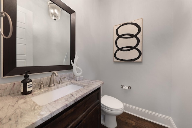 3690 Guinn Gate Dr, Frisco, TX 75034 - half bath with vanity, baseboards, wood finished floors, and toilet