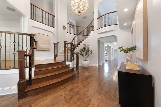 3690 Guinn Gate Dr, Frisco, TX 75034 - foyer entrance featuring arched walkways, stairs, wood finished floors, a chandelier, and a towering ceiling