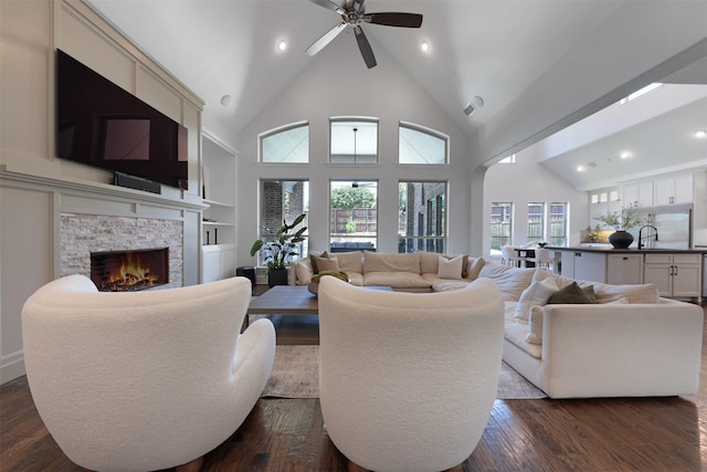 3690 Guinn Gate Dr, Frisco, TX 75034 - living area with a stone fireplace, dark wood-style floors, ceiling fan, recessed lighting, and high vaulted ceiling
