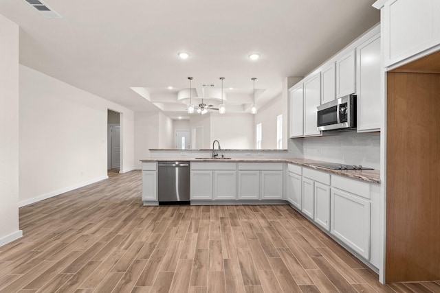 301 Kalura Way, Tool, TX 75143 - kitchen featuring appliances with stainless steel finishes, a sink, light wood-style flooring, a peninsula, and recessed lighting