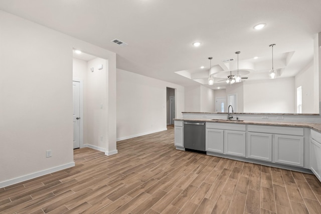 301 Kalura Way, Tool, TX 75143 - kitchen with dishwasher, a raised ceiling, a sink, light wood-type flooring, and recessed lighting