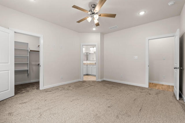 301 Kalura Way, Tool, TX 75143 - unfurnished bedroom with carpet floors, baseboards, a walk in closet, connected bathroom, and ceiling fan