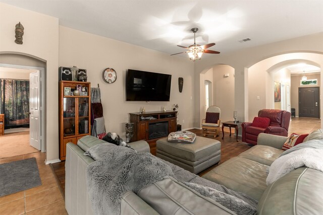 3521 Timber Ridge Trl, Mckinney, TX 75071 - living room with arched walkways, a ceiling fan, tile patterned flooring, and baseboards