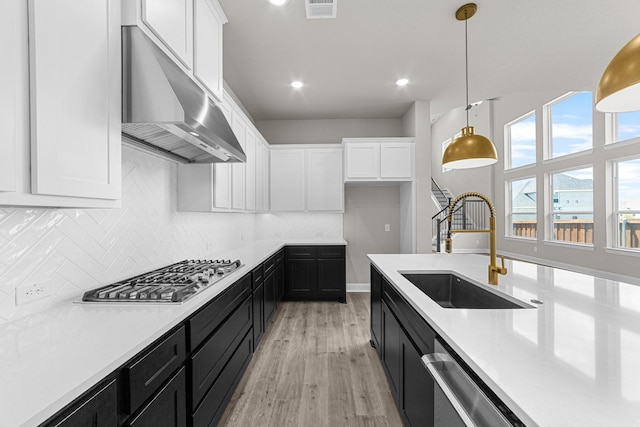 2013 Tolleson Dr, Fort Worth, TX 76008 - kitchen featuring extractor fan, appliances with stainless steel finishes, dark cabinets, a sink, and white cabinetry