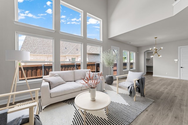 2013 Tolleson Dr, Fort Worth, TX 76008 - living room featuring a chandelier, wood finished floors, a towering ceiling, and baseboards