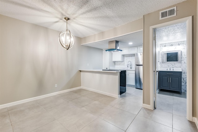 5833 Harvest Hill Rd Unit 2071, Dallas, TX 75230 - kitchen with freestanding refrigerator, island exhaust hood, light tile patterned floors, a textured ceiling, and a peninsula