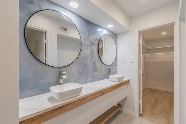 11417 Park Central Pl, Dallas, TX 75230 - bathroom with a spacious closet, double vanity, tile patterned flooring, and recessed lighting