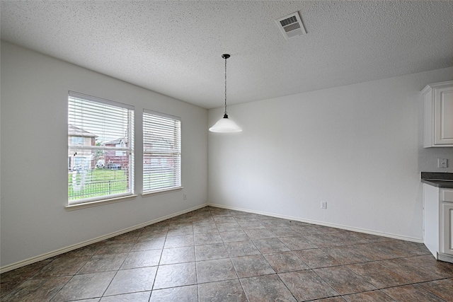 6018 San Marino Ct, Rowlett, TX 75089 - unfurnished dining area featuring a textured ceiling, tile patterned floors, and baseboards