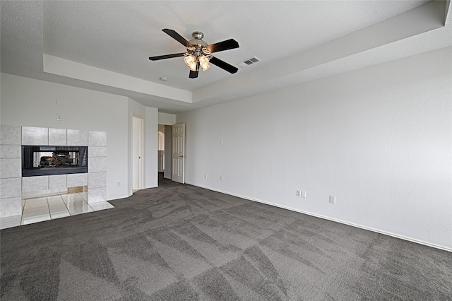 6018 San Marino Ct, Rowlett, TX 75089 - unfurnished living room featuring carpet floors, a raised ceiling, a ceiling fan, a tile fireplace, and baseboards