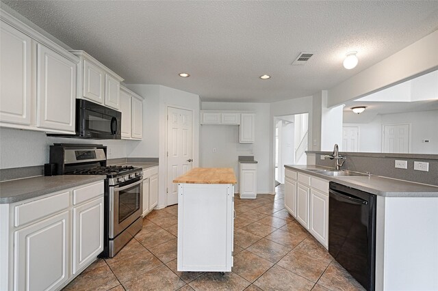 6018 San Marino Ct, Rowlett, TX 75089 - kitchen with black appliances, a sink, an island with sink, recessed lighting, and white cabinets