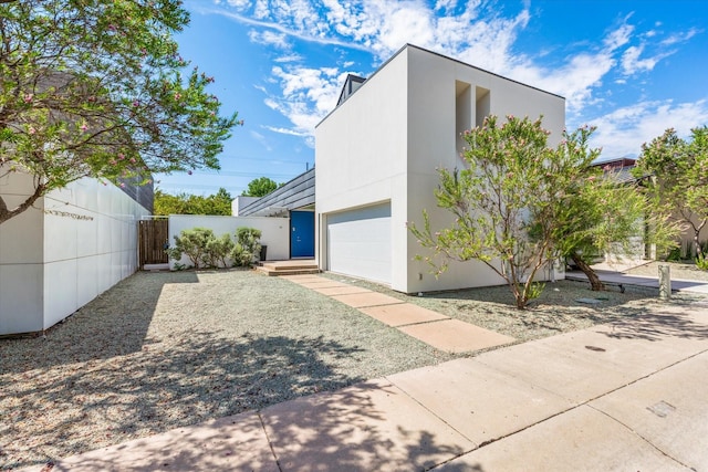 33 Vanguard Way, Dallas, TX 75243 - view of home's exterior with a garage, a gate, and stucco siding