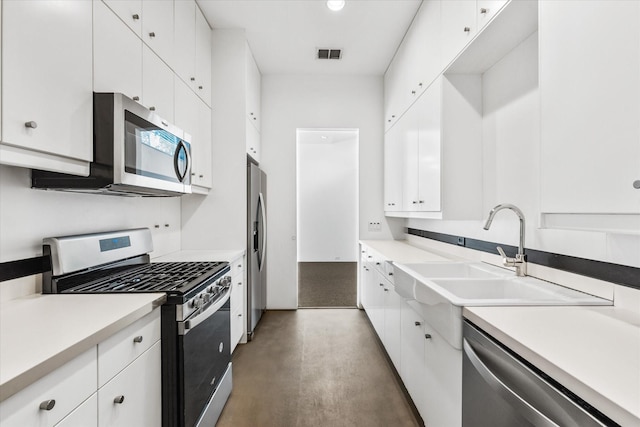33 Vanguard Way, Dallas, TX 75243 - kitchen with stainless steel appliances, finished concrete flooring, white cabinets, a sink, and light countertops