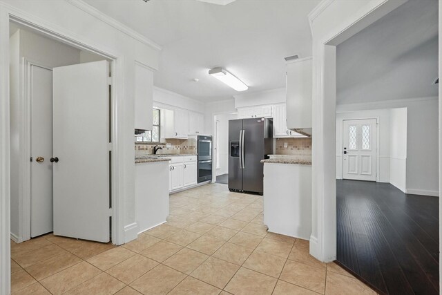 6509 Parkridge Dr, Sachse, TX 75048 - kitchen with appliances with stainless steel finishes, backsplash, white cabinetry, crown molding, and light tile patterned flooring